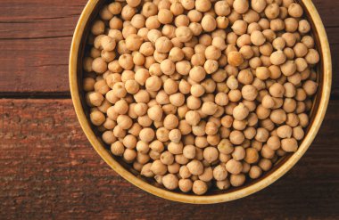 Ahşap arka plan üzerinde kapta nohut. Yatay, tonda