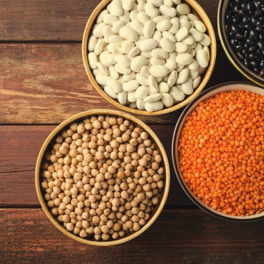 Kase kırmızı mercimek, nohut ve börülce ahşap arka plan üzerinde çeşitli fasulye.