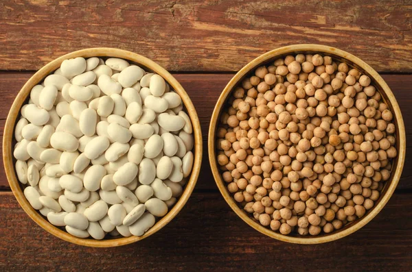 Frijoles surtidos en tazones con garbanzos y frijoles sobre fondo de madera . — Foto de Stock