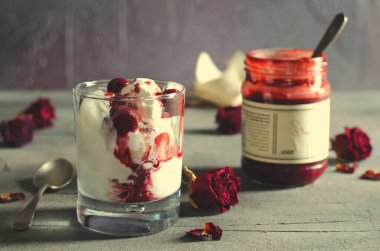 Dondurma dondurma çikolatalı topping ve koyu arka plan üzerinde kurutulmuş gül çiçekleri kiraz. Aşk, Sevgililer günü kavramı. Kopya alanı