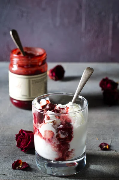 Gelato Sundae con ciliegia in topping cioccolato, e fiori di rosa secchi su sfondo scuro. Amore, concetto di San Valentino. Copia spazio — Foto Stock