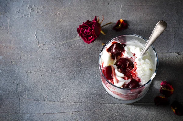 Gelato Sundae con ciliegia in topping cioccolato, e fiori di rosa secchi su sfondo scuro. Amore, concetto di San Valentino. Copia spazio — Foto Stock