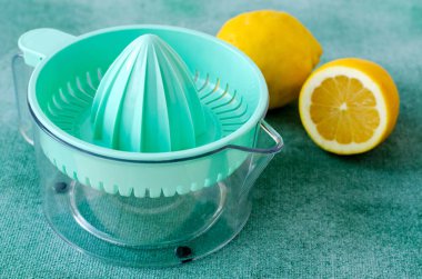 Taze limon turkuaz arka plan üzerinde narenciye sıkacağı ile. Kopya alanı