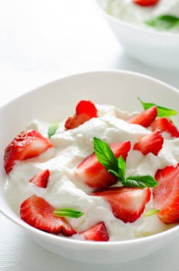 Kase kalın organik Yunan yoğurt ve beyaz backgfound üzerinde taze çilek ile Kahvaltı