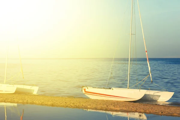 在平静的海面上海滩的白色帆船游艇. — 图库照片