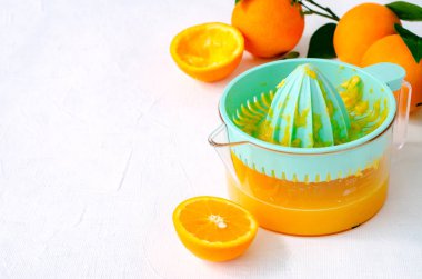 Taze sıkılmış portakal suyu beyaz arka plan üzerinde turkuaz meyve sıkacağı