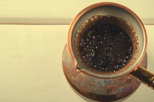 Cafetera de cobre vieja sobre fondo de madera blanca — Foto de Stock