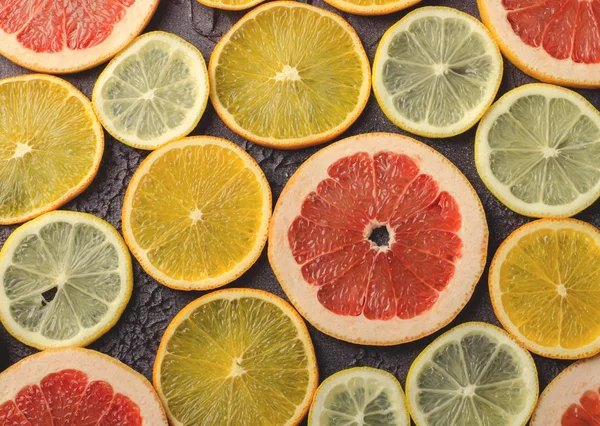 Fatias de frutas cítricas de limão, laranja, toranja no fundo escuro . — Fotografia de Stock