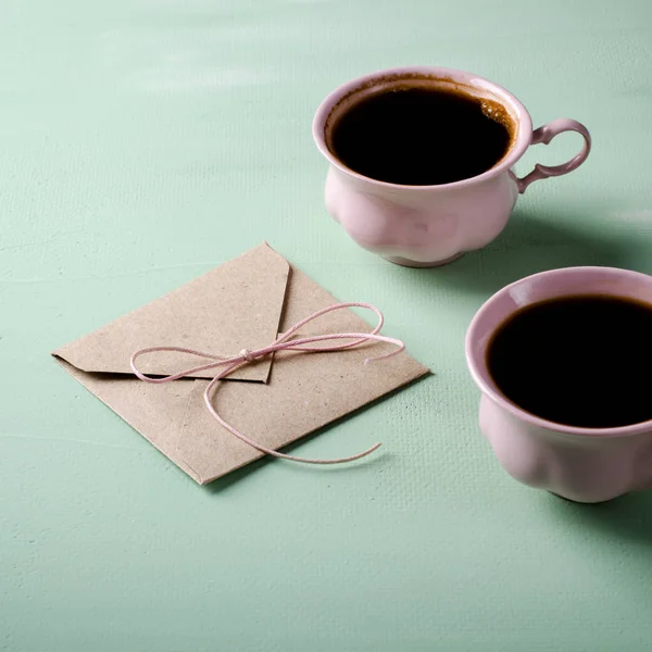 Lettera d'amore, busta e due tazze di caffè rosa. Biglietto di San Valentino. Orizzontale, piatto — Foto Stock