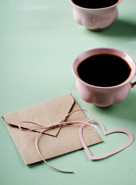 Lettera d'amore, busta e due tazze di caffè rosa. Biglietto di San Valentino. Verticale, piatta — Foto Stock