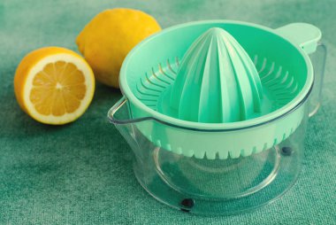 Taze limon turkuaz arka plan üzerinde narenciye sıkacağı ile. . Tonda