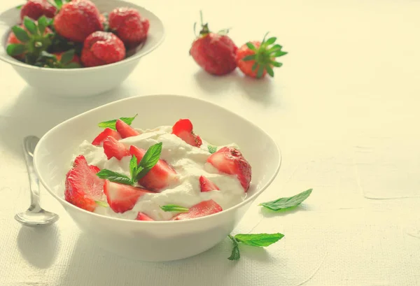 Завтрак с миской густого органического греческого йогурта и свежей клубникой на белом бэкгоне. Toned — стоковое фото