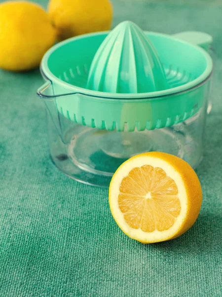 Limones frescos con exprimidor de cítricos sobre fondo turquesa. .. Tonificado —  Fotos de Stock