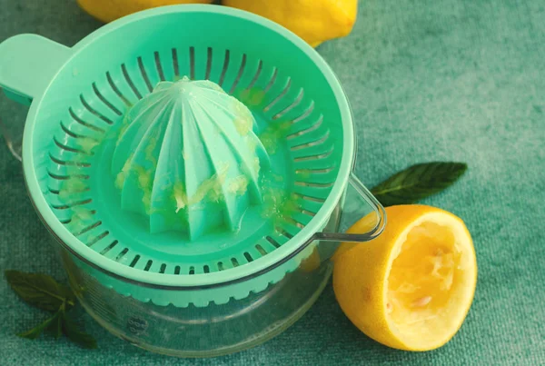 Limones frescos y menta con exprimidor de cítricos sobre fondo turquesa. .. Tonificado — Foto de Stock