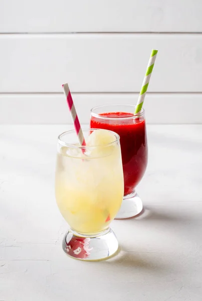 Полуничні смузі та лимонад з коктейльними трубками в окулярах, на білому тлі . — стокове фото