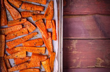 Kavrulmuş karamelli organik havuç ve siyah tepside baharat.