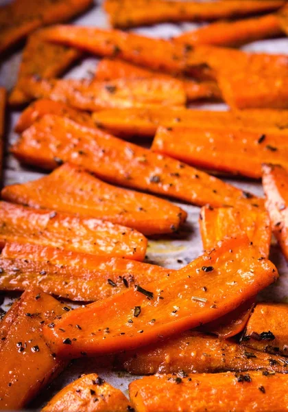 Geroosterde gekarameliseerde biologische wortelen met specerijen op zwarte schaal — Stockfoto