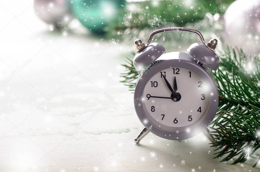 Grey Christmas alarm clock showing midnight, new years eve with decorations on white background