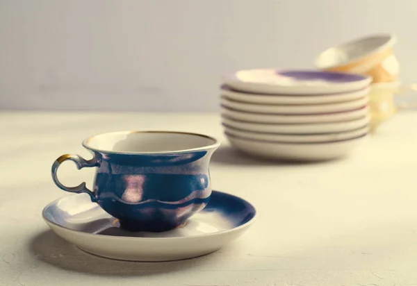 Vajilla de porcelana colorida vacía. Copa azul con plato sobre fondo lila — Foto de Stock