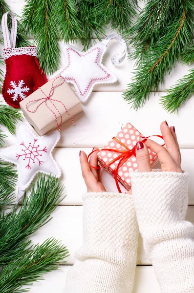 Női kezek kezében karácsonyi ajándék doboz fehér háttér. Függőleges, felülnézet. — Stock Fotó