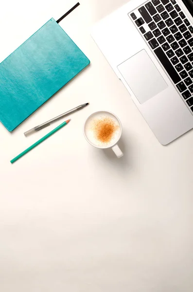 Praca przestrzeń z laptopa, turkus notebook i cynamon kawa na biały stół. Widok płaski świeckich, top — Zdjęcie stockowe