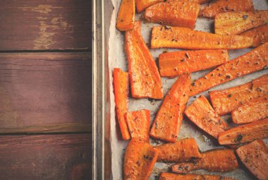 Kavrulmuş karamelli organik havuç ve siyah tepside baharat.