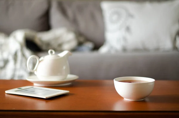 Accogliente interno casa con teiera, tazza di tè e eBook — Foto Stock