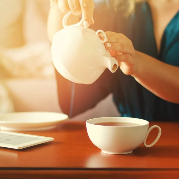 Accogliente interno casa con teiera, tazza di tè e eBook — Foto Stock