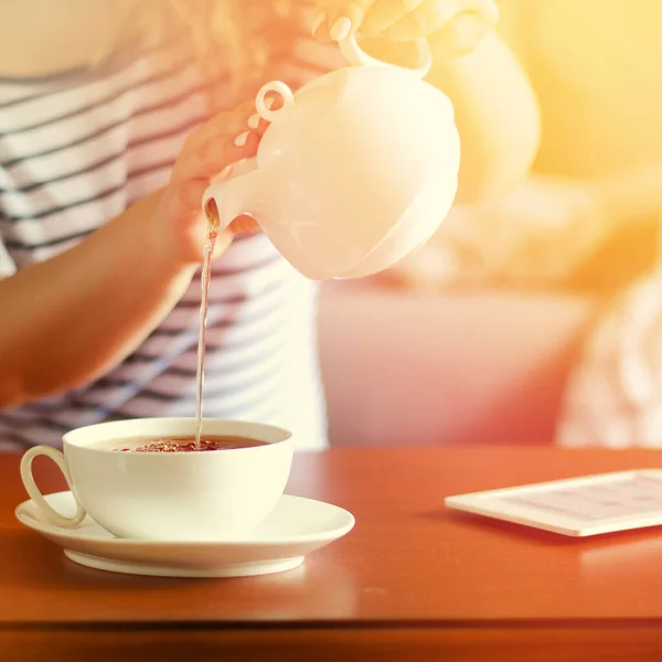 Accogliente interno casa con teiera, tazza di tè e eBook — Foto Stock