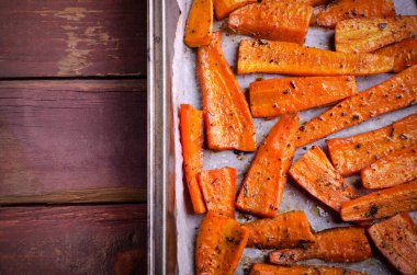 Kavrulmuş karamelli organik havuç ve siyah tepside baharat.