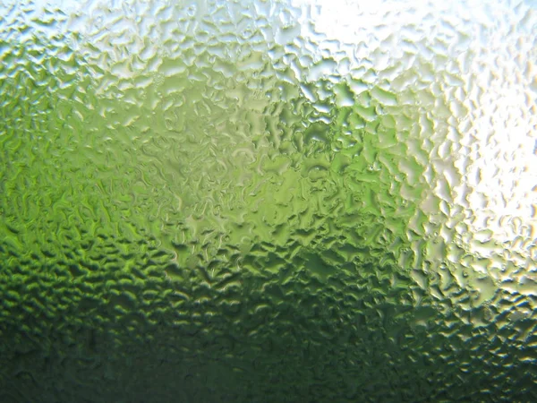 Krople wody na zielone szkło przejrzyste z bliska — Zdjęcie stockowe