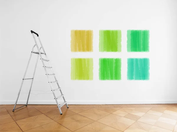 Ladder in empty room, white wall with colored paint samples — Stock Photo, Image