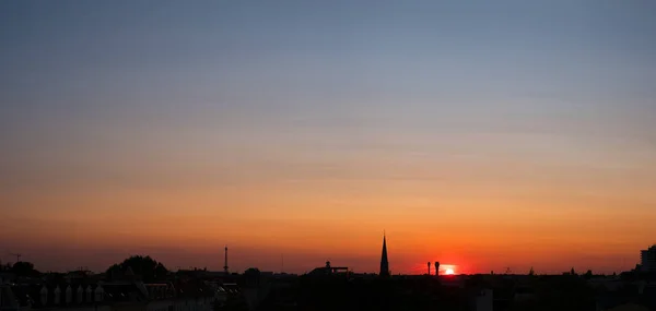 夕阳西下的天空笼罩着城市 多彩的天空笼罩着屋顶 — 图库照片