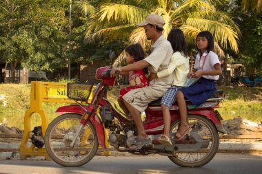 Siem Reap, Kamboçya - Ocak 2014: 4 kişilik bir aile sokakta motosiklet / scooter kullanıyor