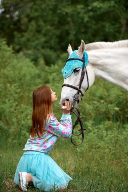 Kızıl saçlı kız ve beyaz at ormandaki