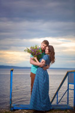 Günbatımı gökyüzü arka plan üzerinde eski köprüde aşık güzel Çift