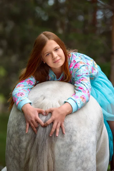 Pelirroja y caballo blanco en el bosque — Foto de Stock