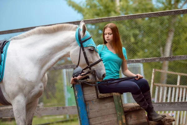 Reiterin und ihr Pferd ruhen sich nach dem Reiten in der Nähe des Stalls aus — Stockfoto