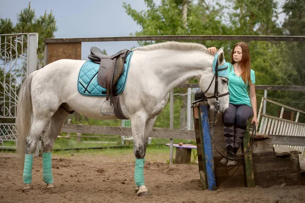 Flicka rider och hennes häst att vila nära stallet efter ridning — Stockfoto