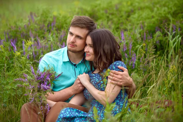 相爱的双方一起坐在花中间的草地上。蜜月 — 图库照片