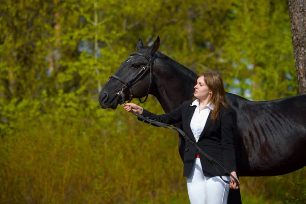 Ung Flicka Ryttare Med Svart Häst Våren Utomhus Scen — Stockfoto