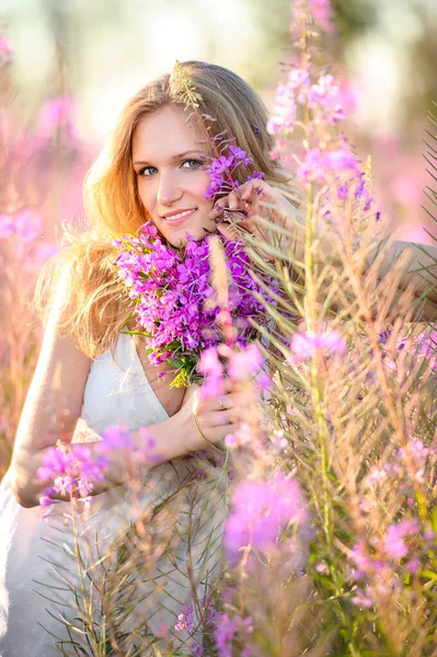 Молодая Красивая Блондинка Собирает Розовые Цветы Весеннем Цветущем Поле Закате — стоковое фото