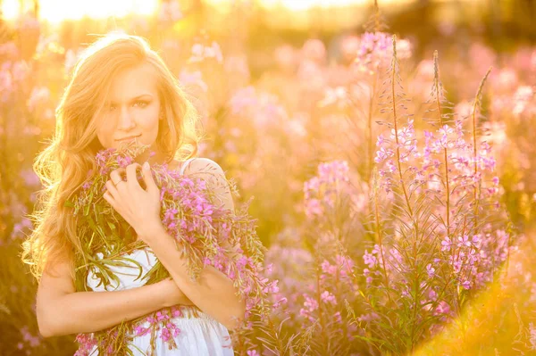 Młoda Piękna Blondynka Zbiera Różowe Kwiaty Polu Kwitnącym Wiosną Zachodzie — Zdjęcie stockowe