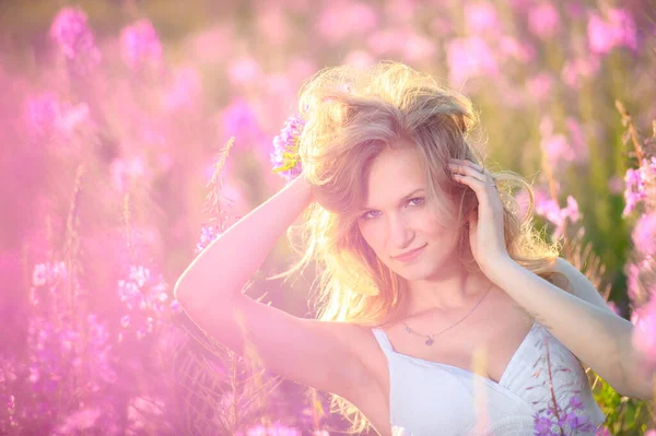 Młoda Piękna Blondynka Zbiera Różowe Kwiaty Polu Kwitnącym Wiosną Zachodzie — Zdjęcie stockowe