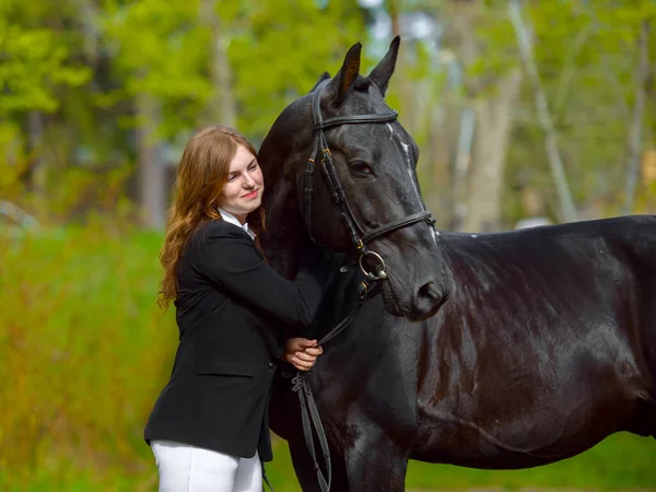 Nuori Tyttö Ratsastaja Musta Hevonen Keväällä Ulkona Kohtaus — kuvapankkivalokuva