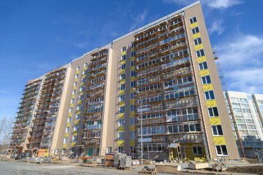 Yeni bir konut inşaatı. Bina cephesi. Aşağıdan geniş açılı bir mercekle çekilmiş. Yüksek binalar modern mimari ufuk çizgisi.