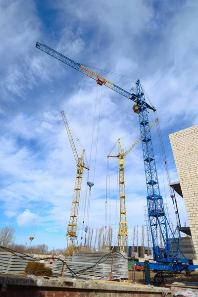 Hausbau Fotos Von Hochhausbaukränen Und Einem Unfertigen Haus Vor Blauem — Stockfoto