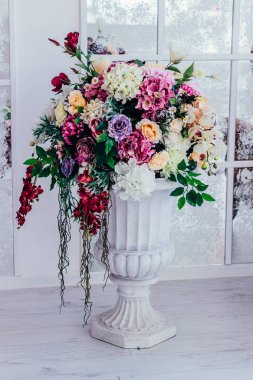 Büyük, beyaz bir vazoda parlak, güzel bir buket.