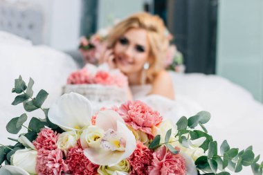 Arka planda bir düğün pastası ile ön ve çok güzel bir gelin düğün buketi