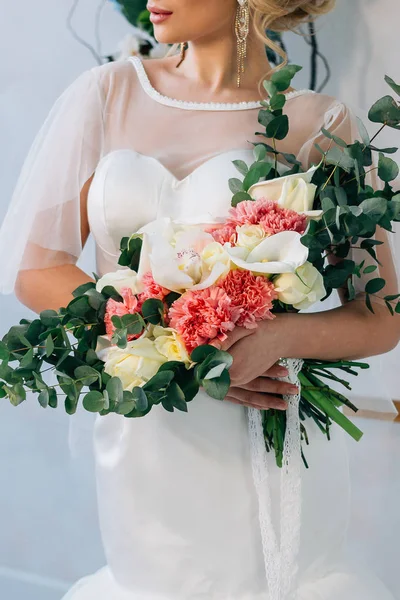 Esküvői csokor fehér esküvői ruha a gyönyörű menyasszony kezében — Stock Fotó